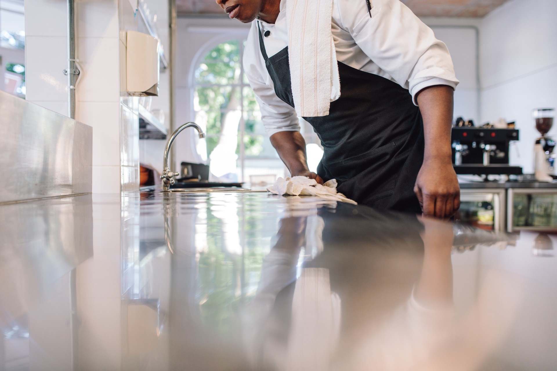 Waiter wiping the counter top in the kitchen