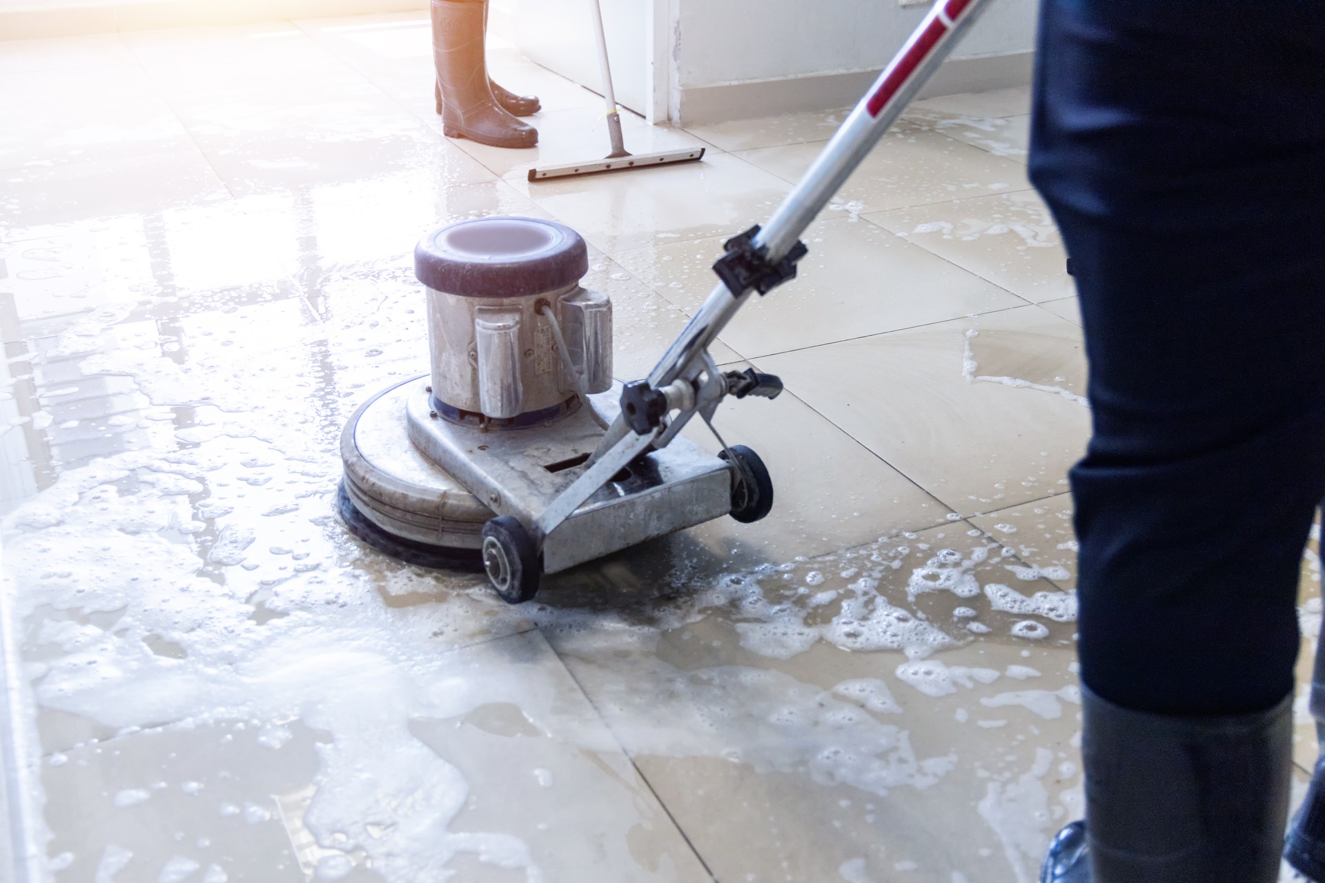 Janitor use floor scrubber machine on the floor hallway office building or walkway after school and classroom work job with sun light background.